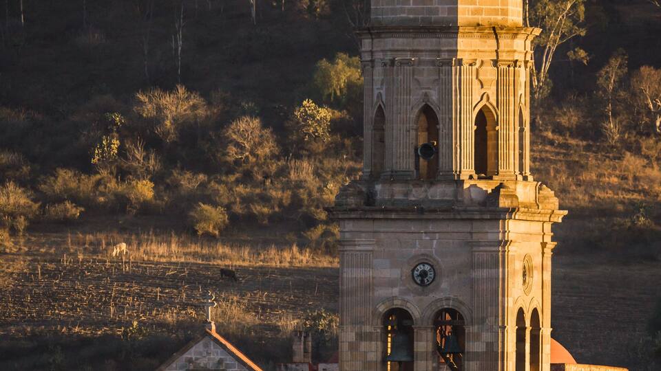 A church with a bell tower and a smaller building with a red roof.