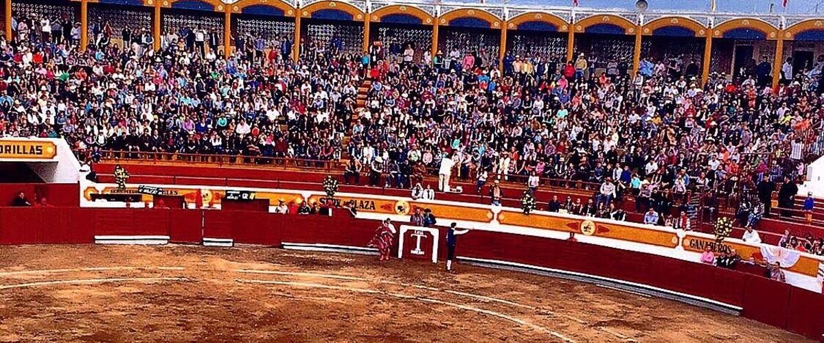 A bullfighting arena with spectators in the stands.