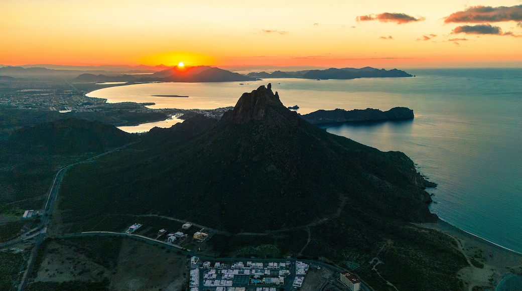 Spectacular aerial shot of the sunrise. The sun rises over the horizon illuminating the calm bay of San Carlos Sonora, Mexico and its iconic Tetakawi mountain.default