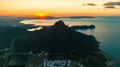 Spectacular aerial shot of the sunrise. The sun rises over the horizon illuminating the calm bay of San Carlos Sonora, Mexico and its iconic Tetakawi mountain.default