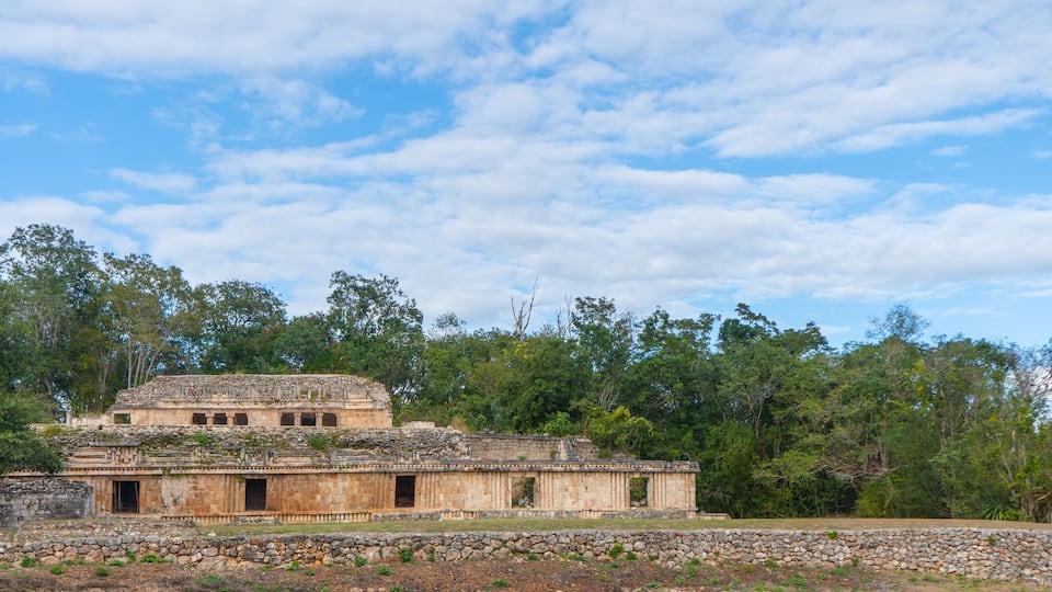 An ancient stone structure surrounded by dense forest.