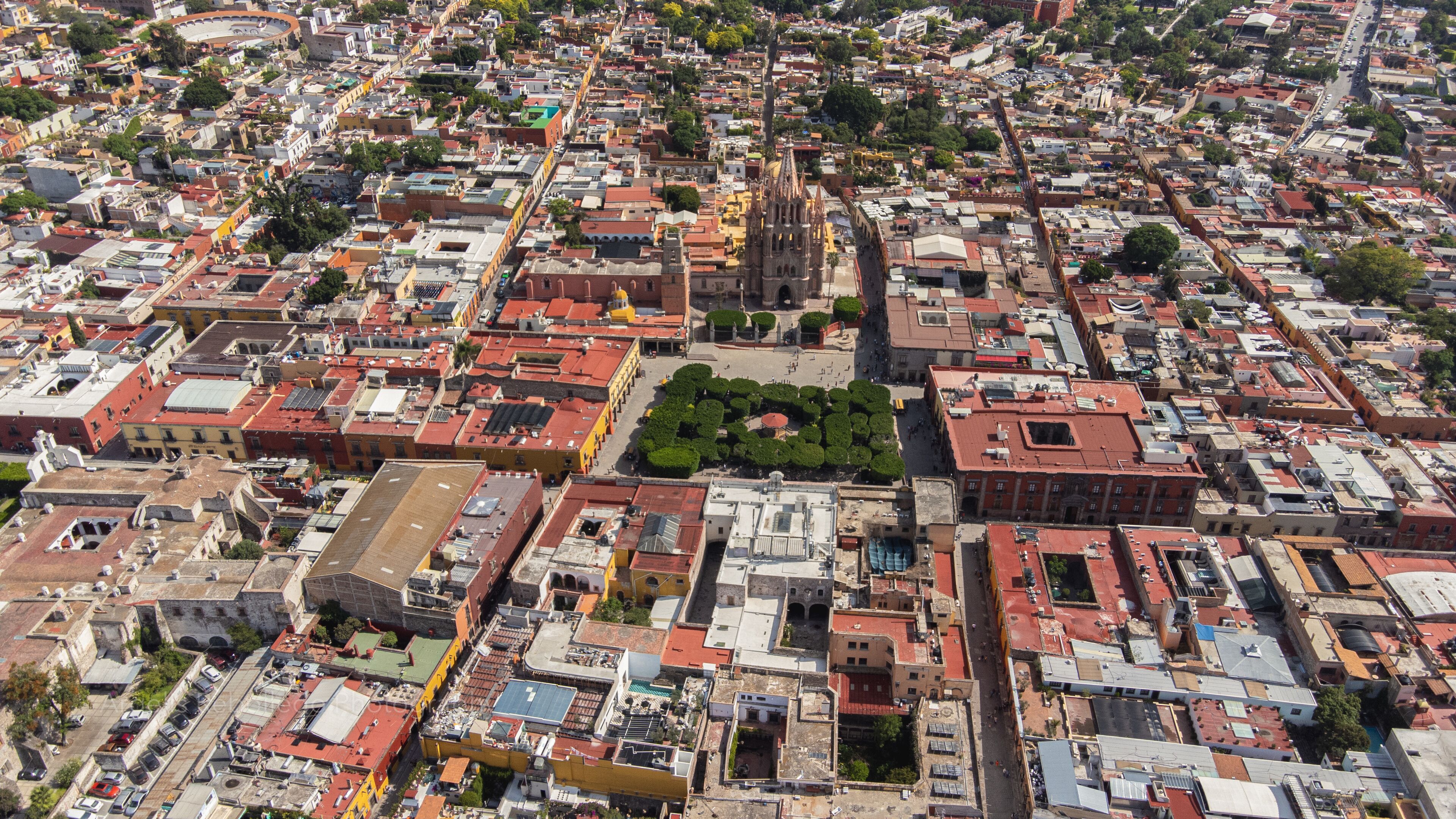 the church Parroquia Archangel Jardin Town Square Night Tree Decoraciones San Miguel de Allende, México. Parroaquia. Night and morning light in a drone view.