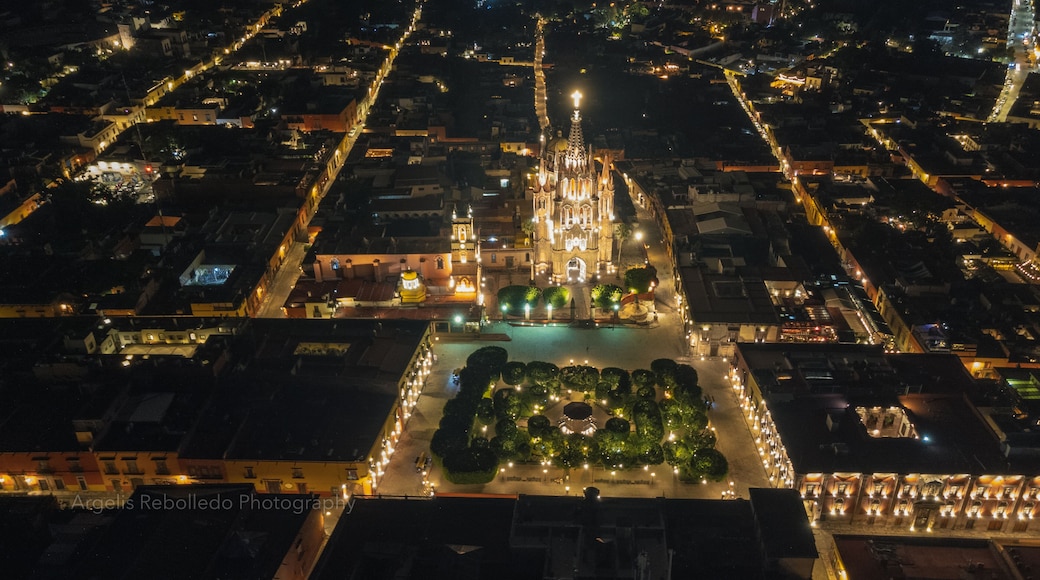 the church Parroquia Archangel Jardin Town Square Night Tree Decoraciones San Miguel de Allende, México. Parroaquia. Night and morning light in a drone view.