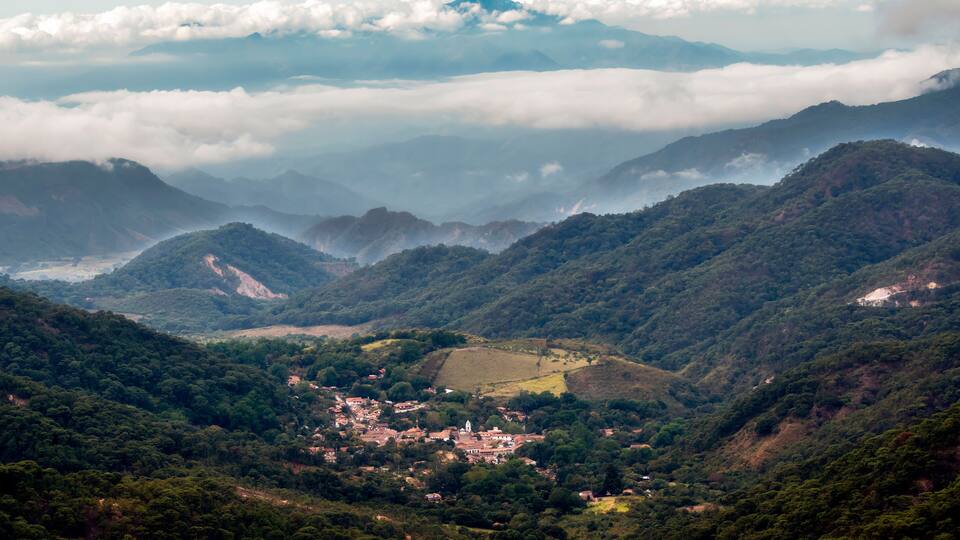 A mountainous landscape with a village nestled in a valley.