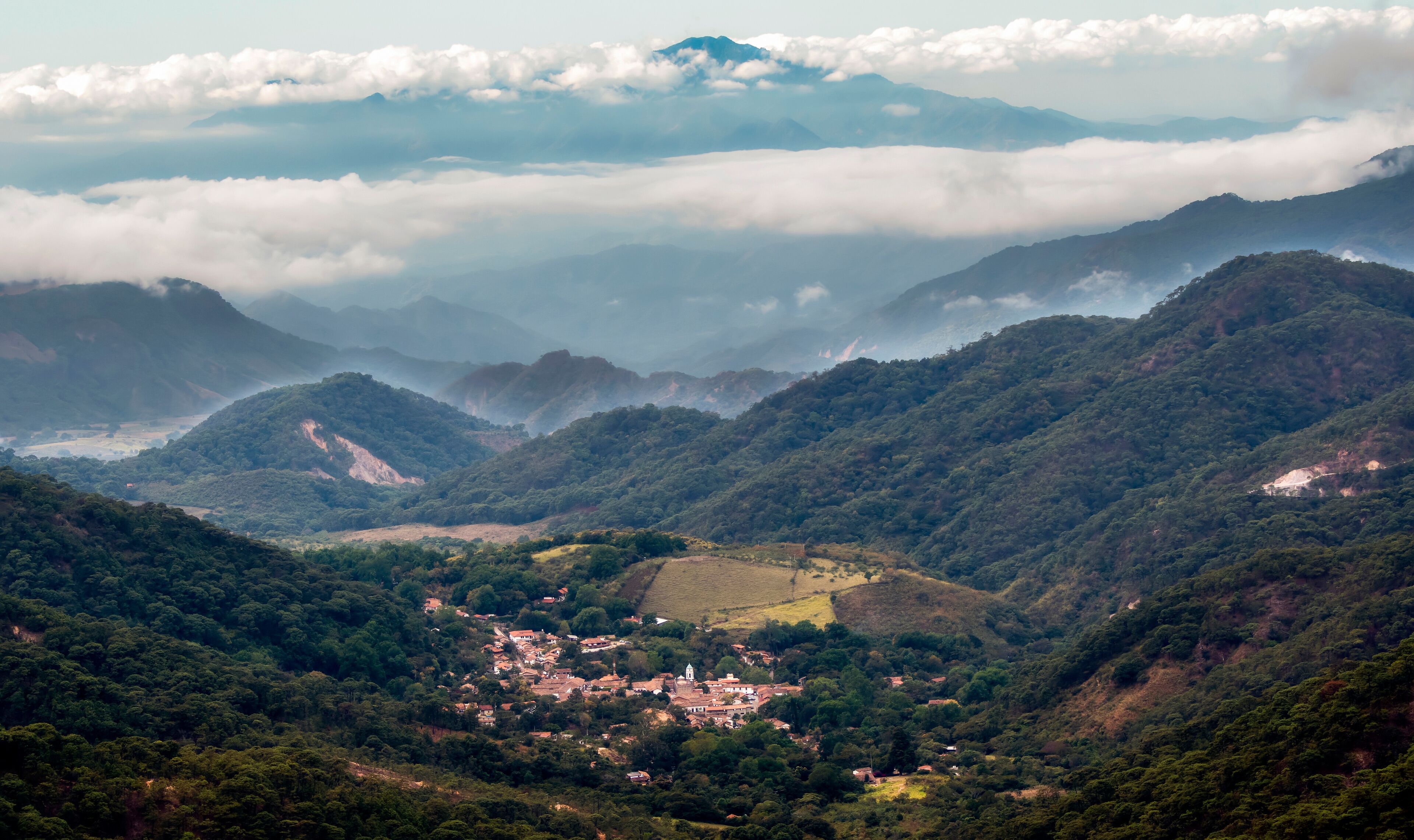 A mountainous landscape with a village nestled in a valley.