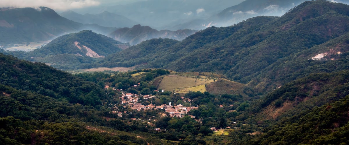 A mountainous landscape with a village nestled in a valley.