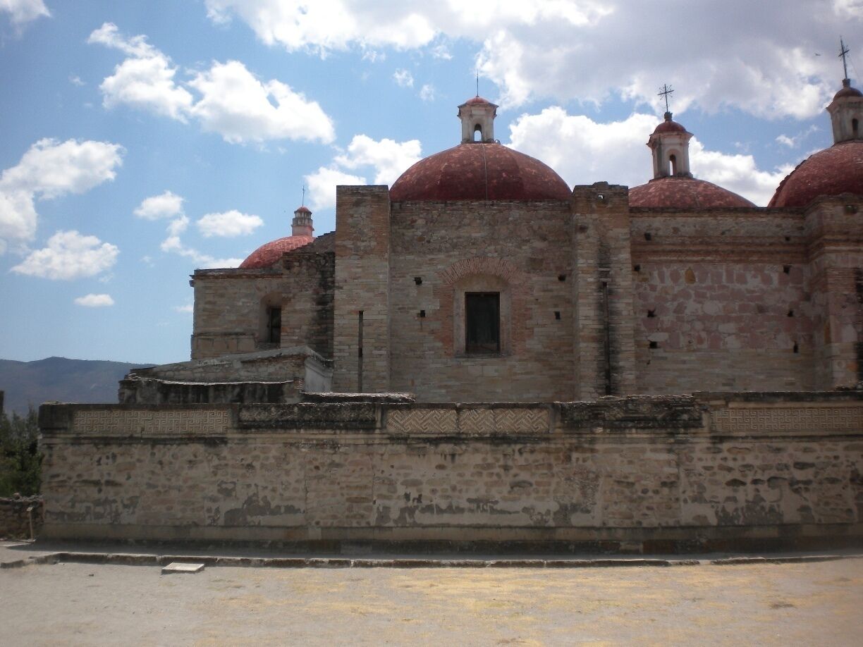 A historic building with red domes and a stone wall.