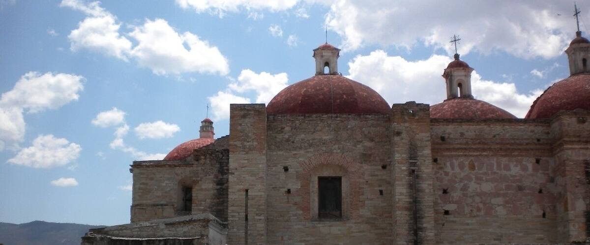 A historic building with red domes and a stone wall.