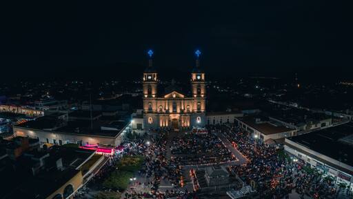 Drone shot of a crowd of people in front of Juan Bautista church celebrating Easter night in Tuxpan