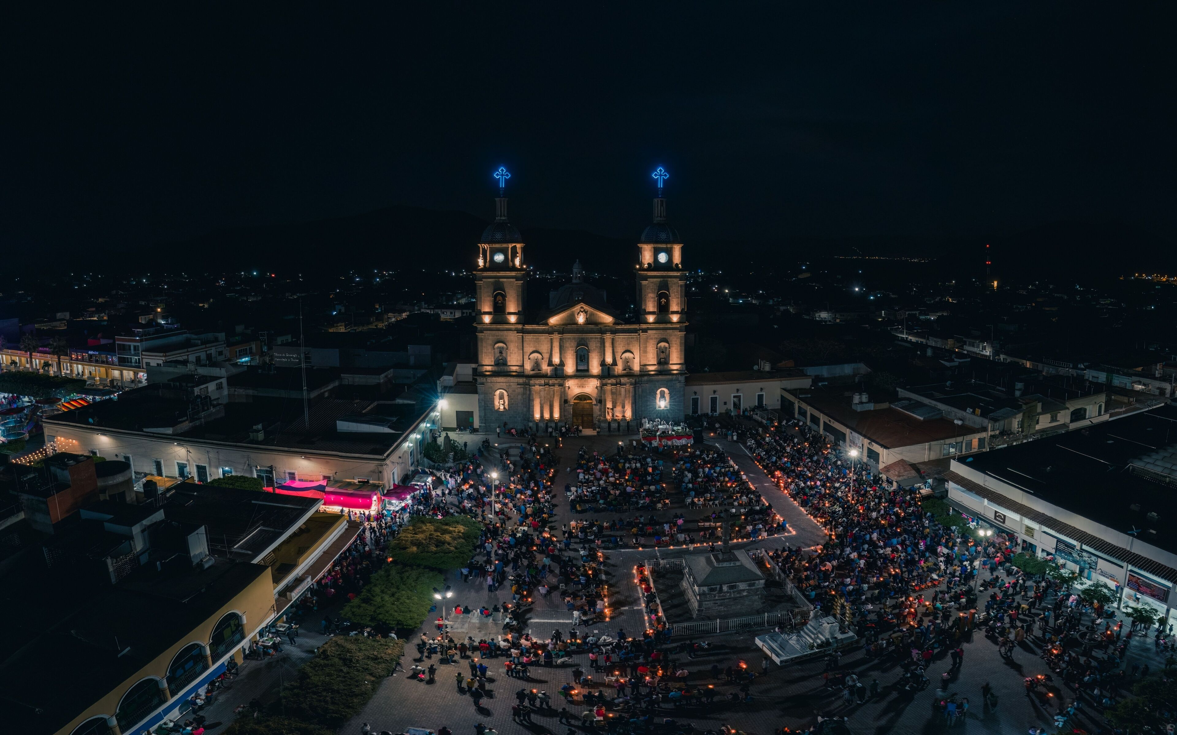 A large cathedral with two towers, surrounded by a crowd of people.