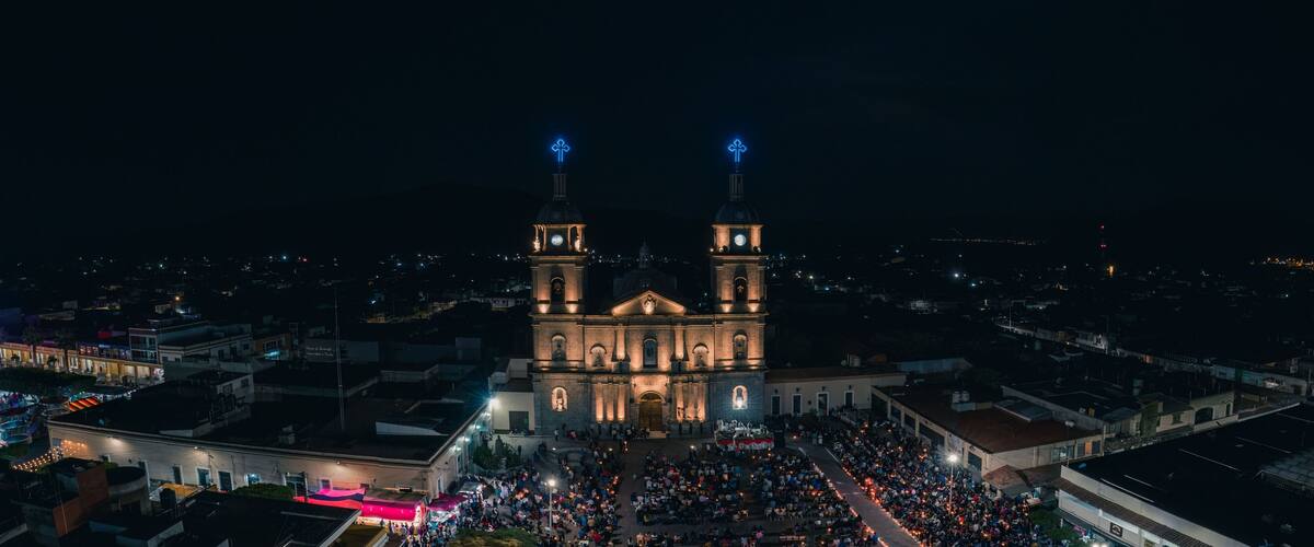 A large cathedral with two towers, surrounded by a crowd of people.