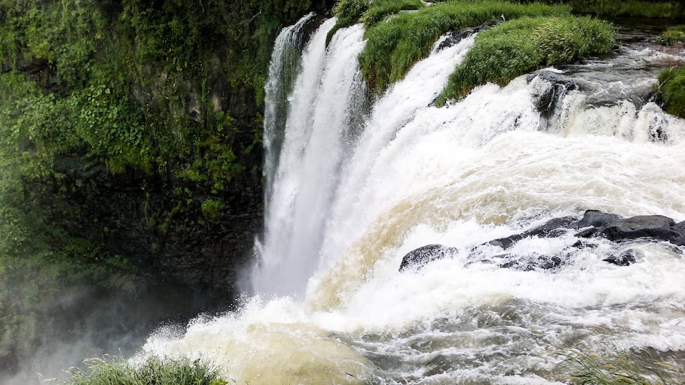 A powerful waterfall cascading over moss-covered rocks.