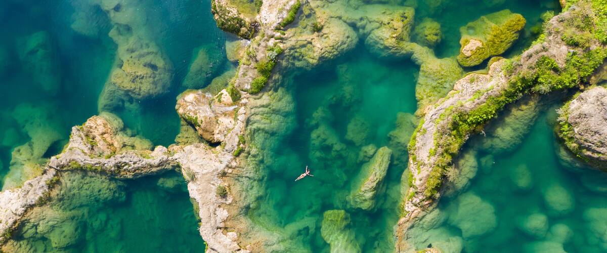 Aerial view of woman in swimsuit bathing in the El Salto waterfalls, Mexico.
