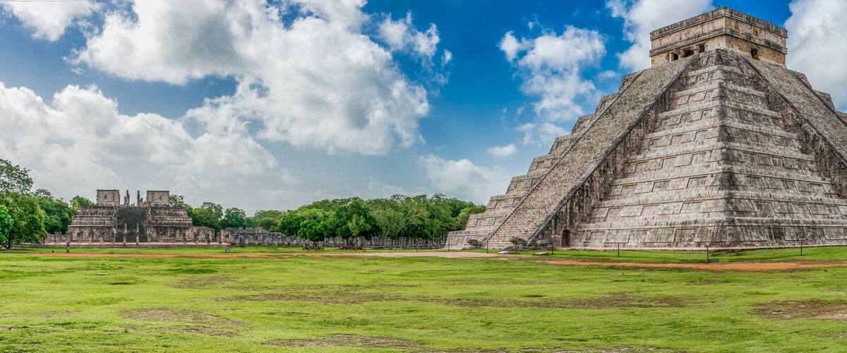 A large pyramid with a stepped structure and a smaller temple in the background.