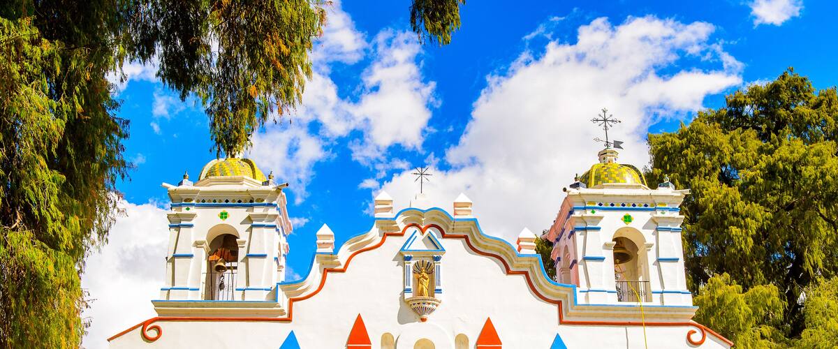 A church with two domes, blue and red accents, and a cross on top.