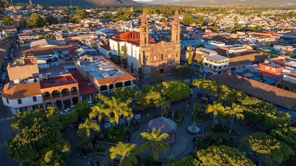 A town with a prominent church, a central plaza, and surrounding residential buildings.