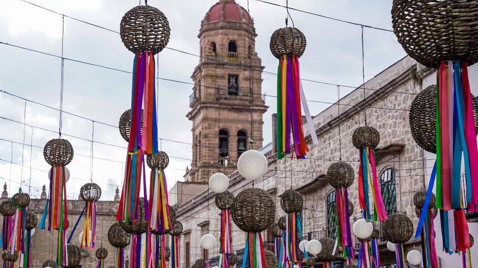 A historic building with a bell tower and colorful decorations.