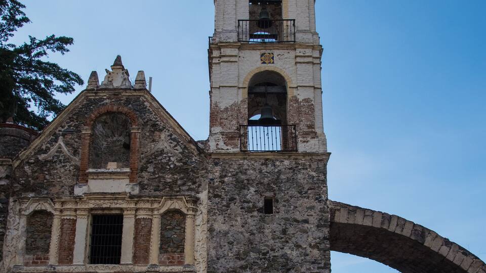 A historic church with a bell tower and an arched doorway.