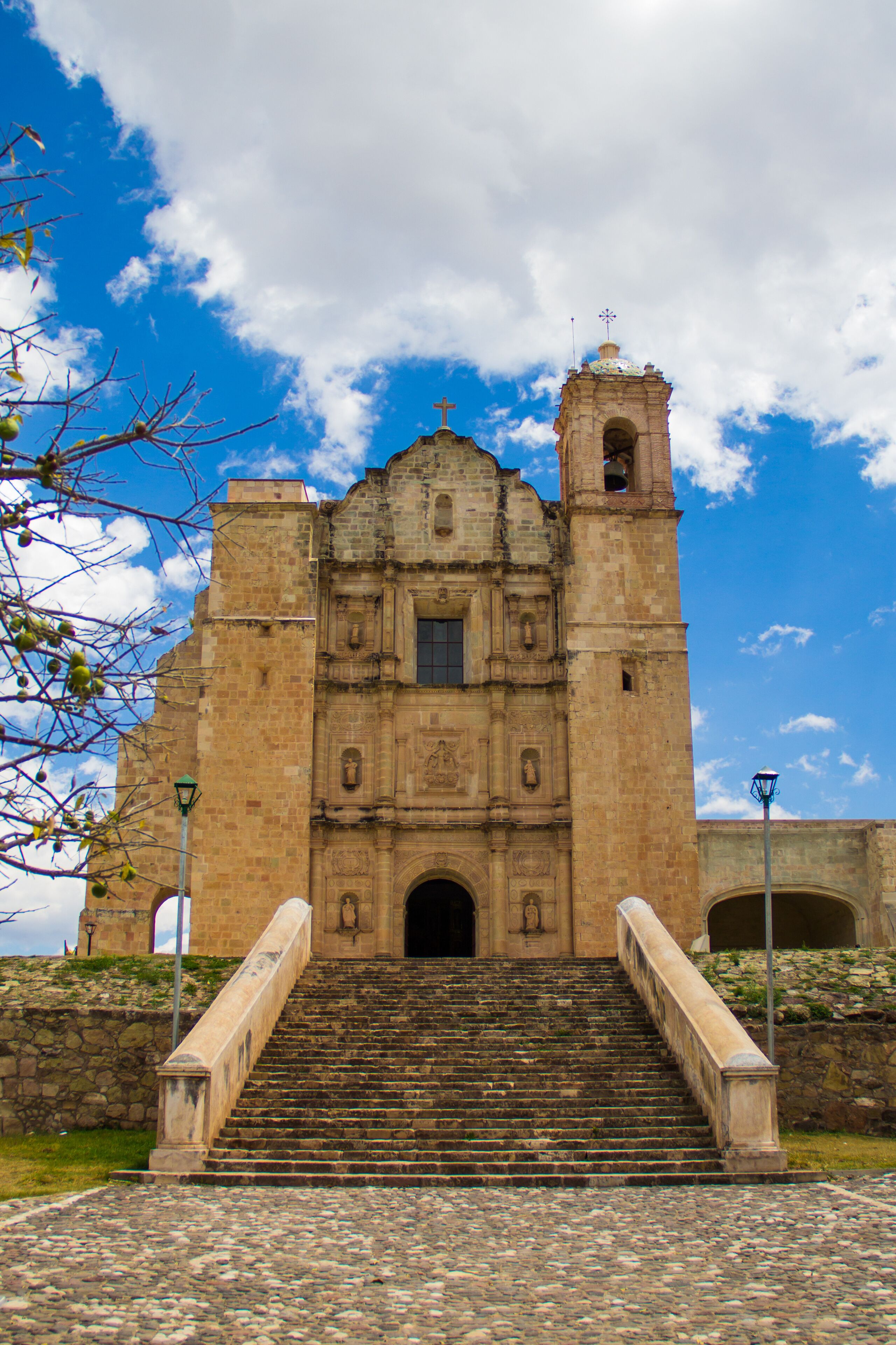 A historic church with a bell tower and a staircase leading up to the entrance.