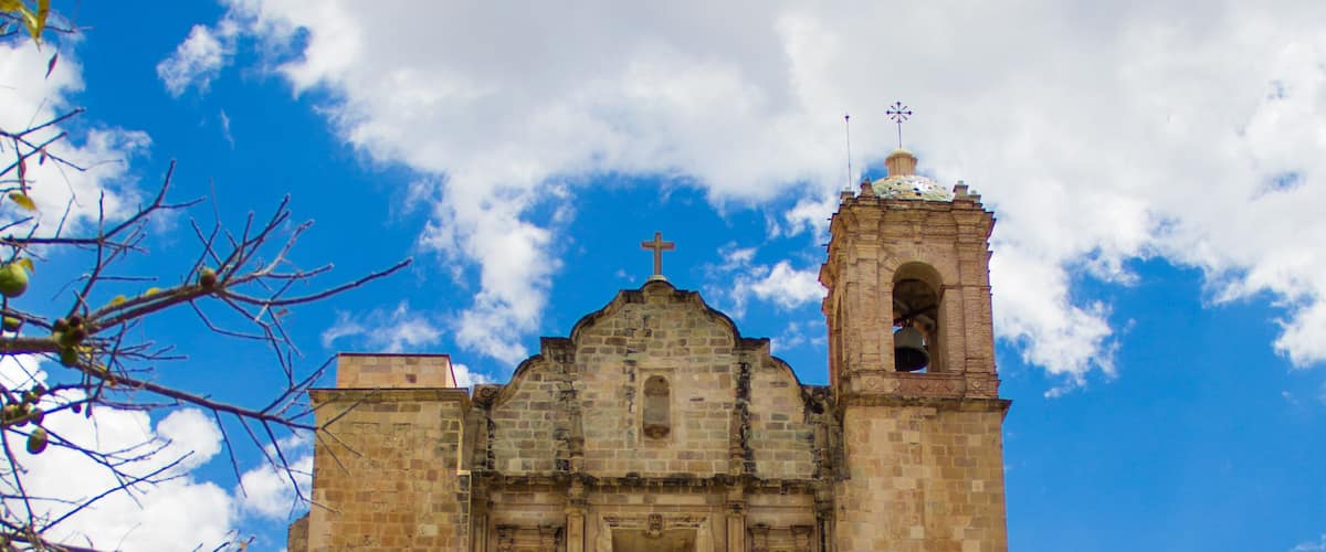 A historic church with a bell tower and a staircase leading up to the entrance.