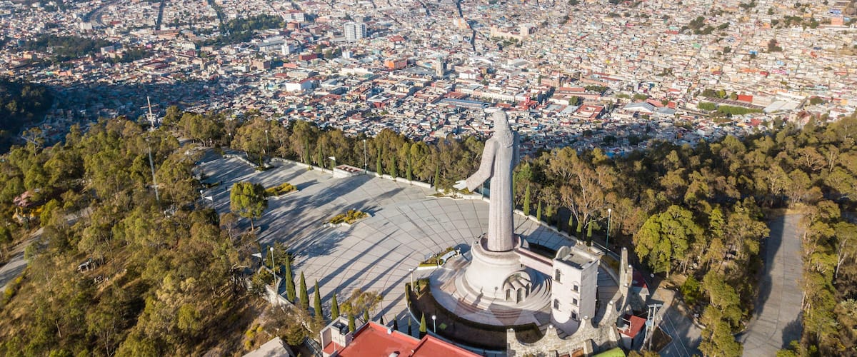 An aerial view of a city with a prominent monument surrounded by trees.