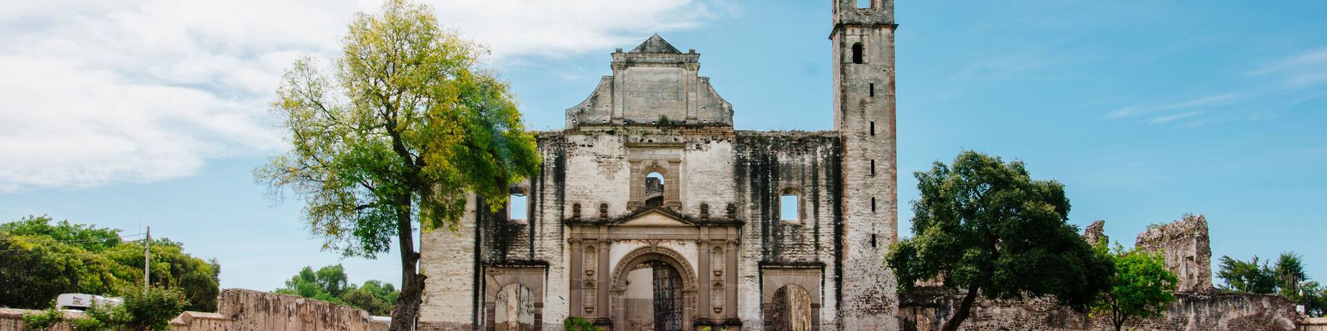 Front view of a old church with a garden