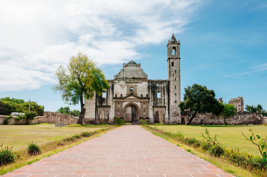 Front view of a old church with a garden