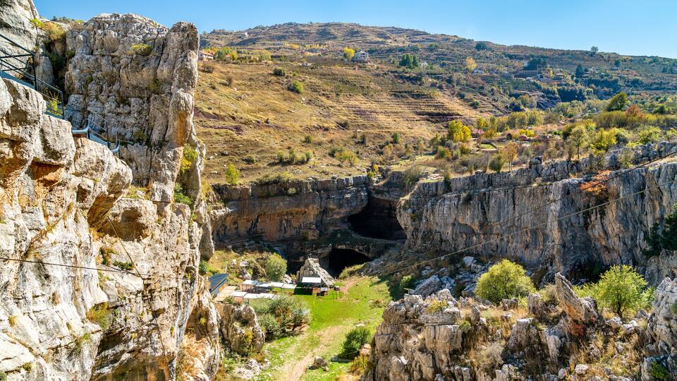 A rocky gorge with a small settlement at its base.