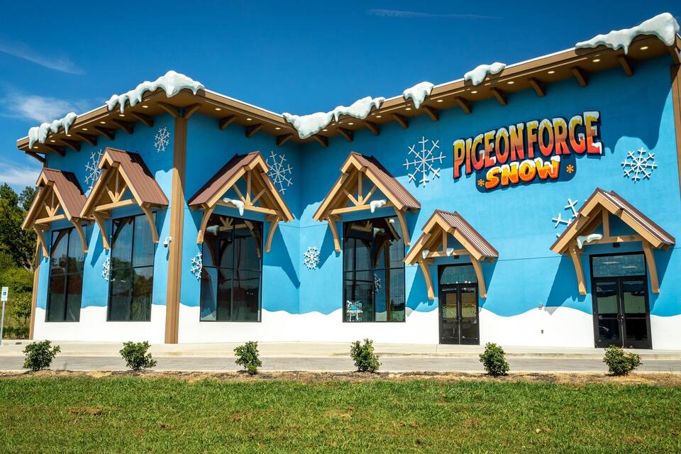 Um edifício com fachada azul e decorações de flocos de neve, chamado "Pigeon Forge Snow".