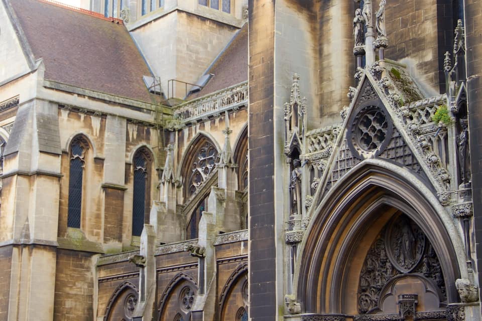 A historic building with intricate stonework, pointed arches, and detailed carvings.