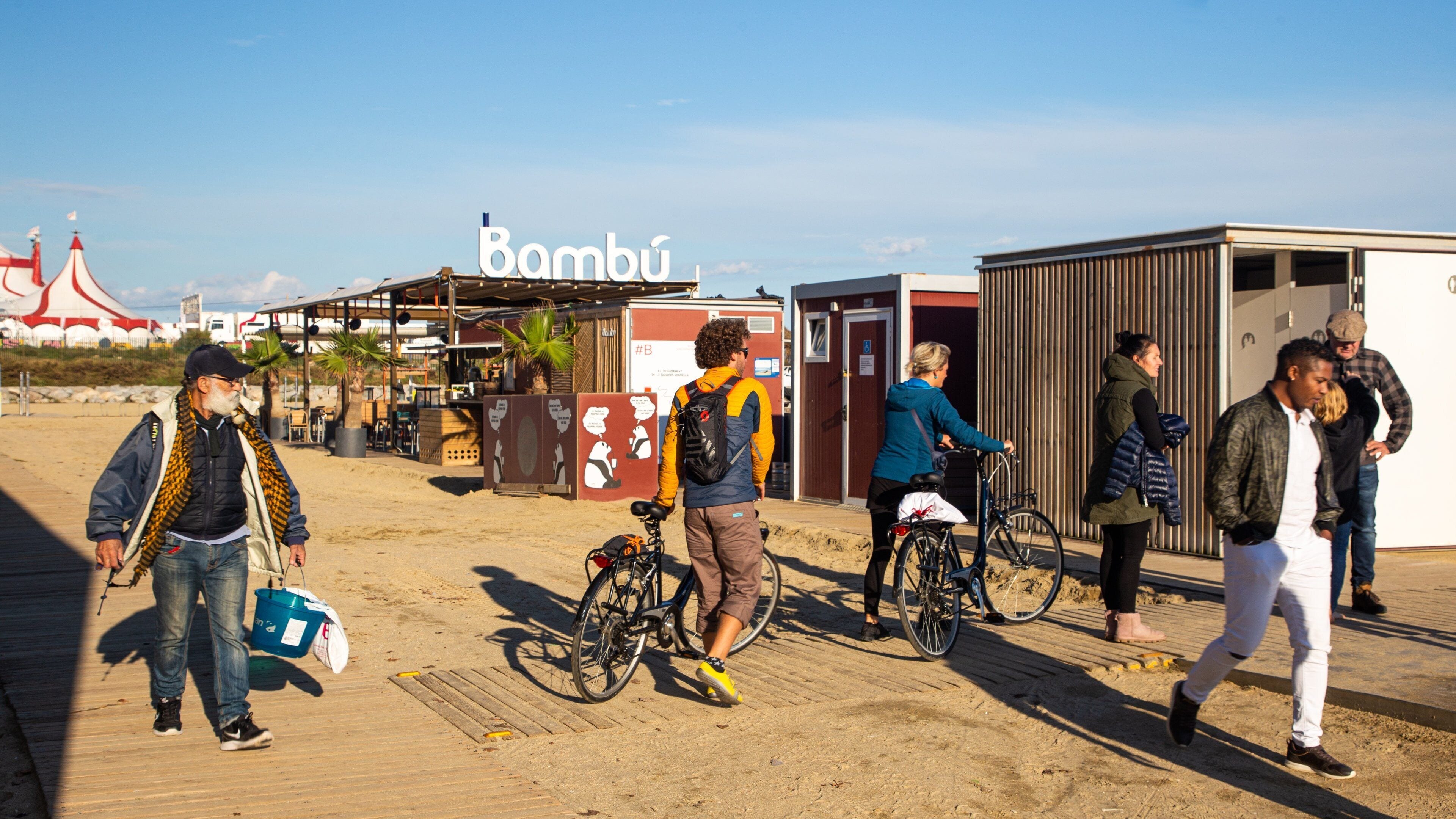 Llevant Beach showing a beach bar and a beach as well as a small group of people