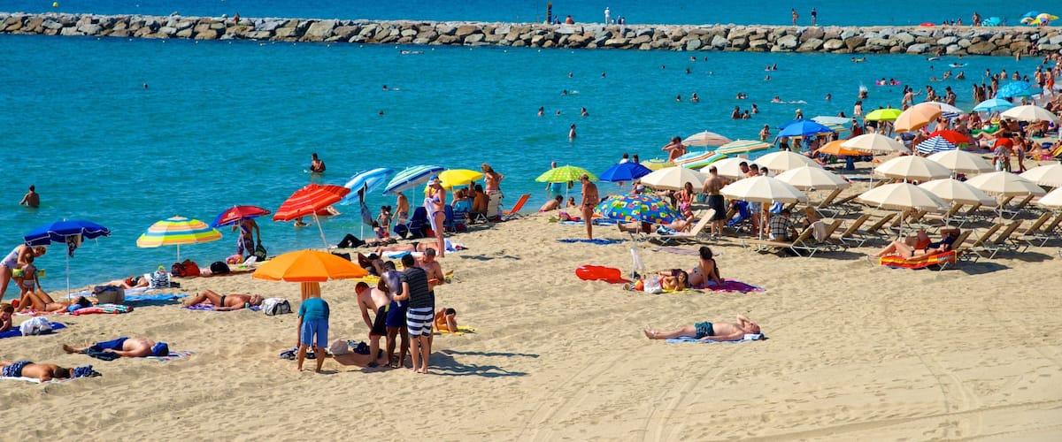 Barcelona which includes swimming and a beach as well as a large group of people