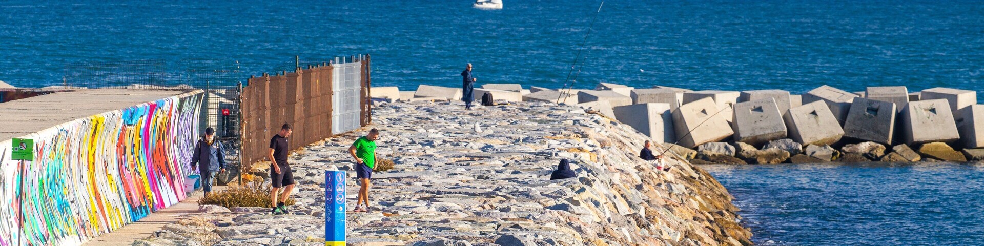Llevant Beach featuring general coastal views as well as a small group of people