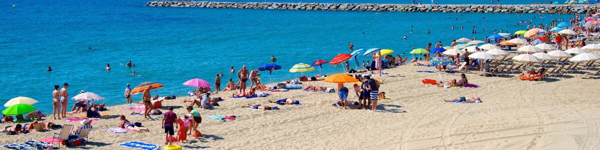 Barcelona showing a sandy beach as well as a large group of people