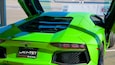 A bright green Lamborghini with its doors open, revealing the interior.
