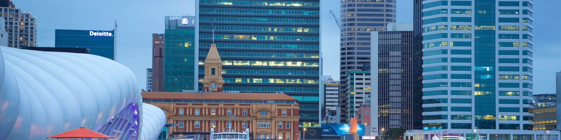 Un frente marítimo con edificios modernos, incluyendo HSBC y ANZ, y una gran estructura blanca.