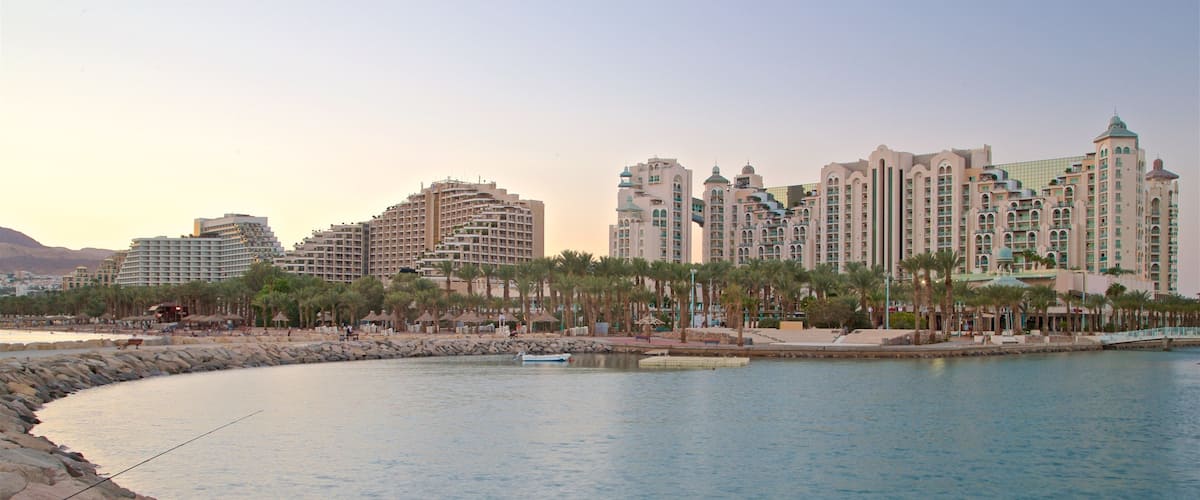 Eilat que incluye un hotel o resort de lujo, vistas generales de la costa y una puesta de sol