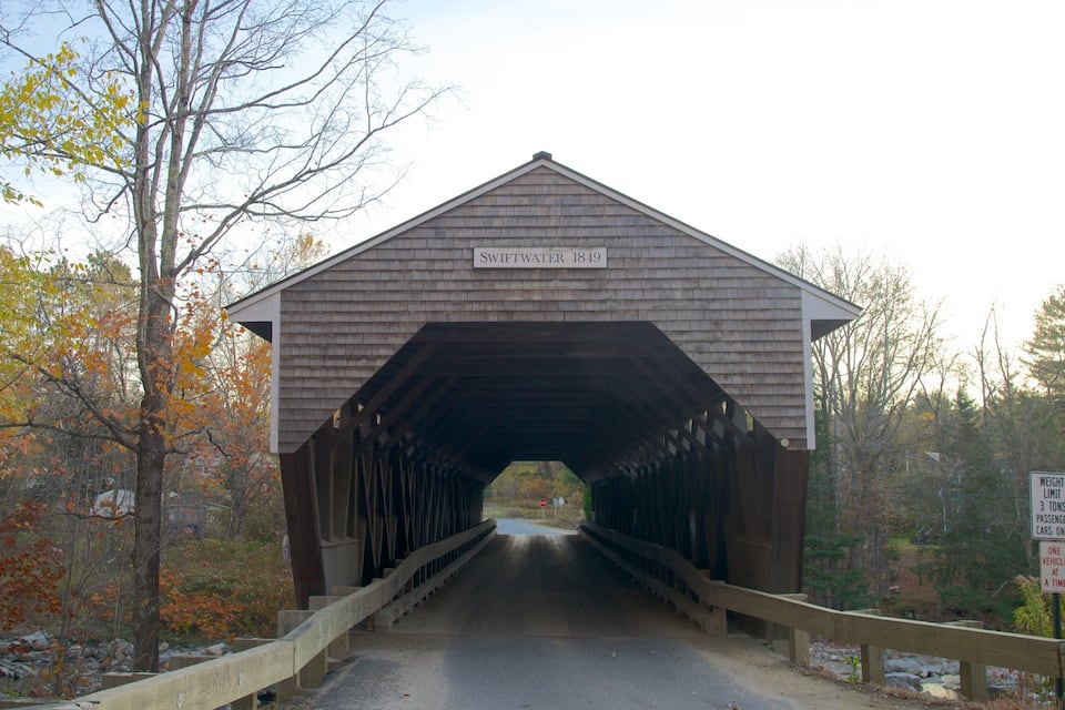 A covered bridge named Swiftwater 1849 with a weight limit sign for passenger cars.