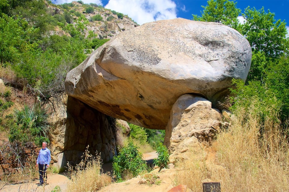 A large rock formation with a person standing nearby.