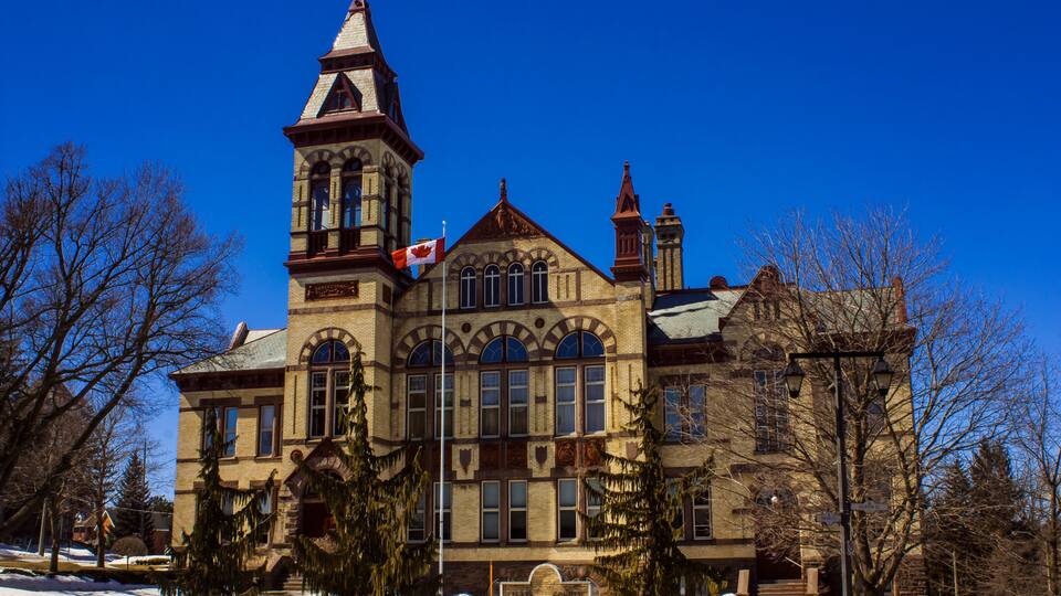 A large, historic building with a prominent tower and arched windows.