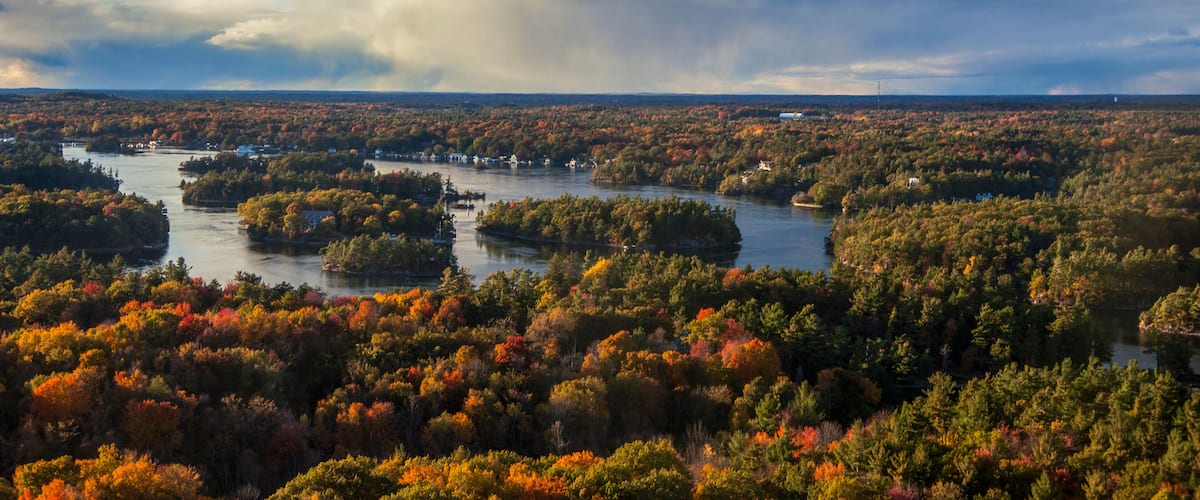 A river winding through a densely forested area with autumn foliage.