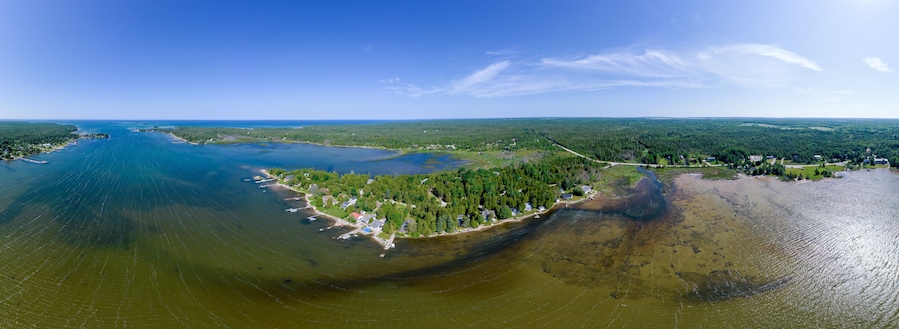 Lake view with huts cottages and summer cabins in the dense forest. Beautiful natural scene with fishing houses and property for rent and summer picnic. Huron Lake.