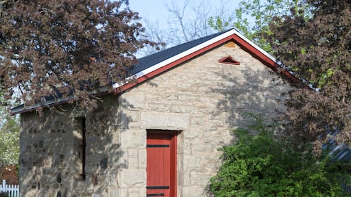 Historic 1892 stone jailhouse with a bright red door in Creemore, Ontario. Known as the smallest jail in North America, this little fieldstone lock-up is a famous heritage landmark.