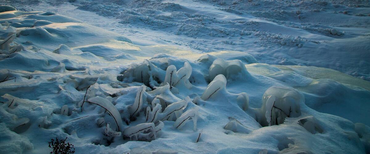 A frozen landscape with snow-covered terrain and ice formations.