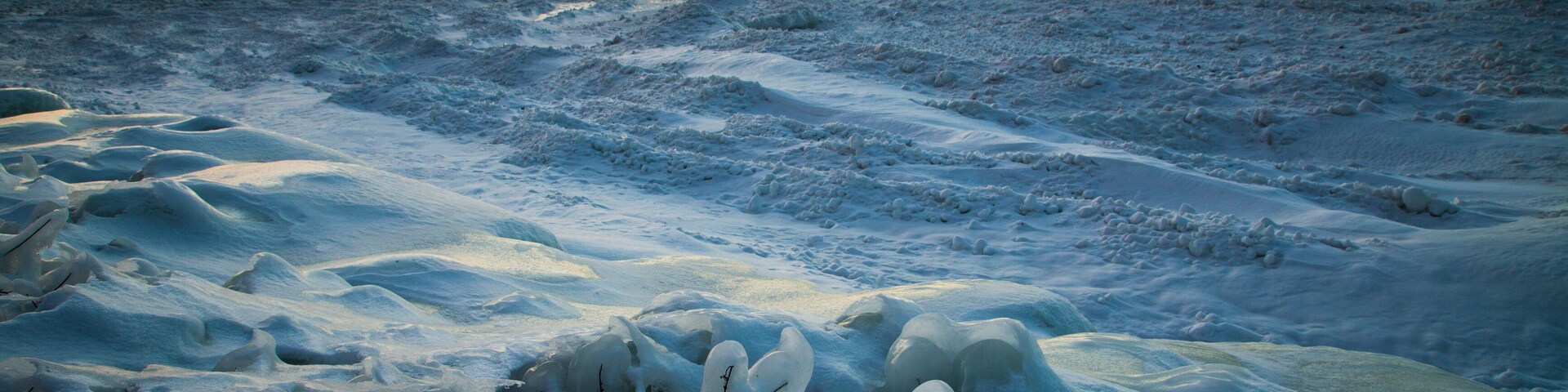 Un paisaje helado con terreno cubierto de nieve y formaciones de hielo.