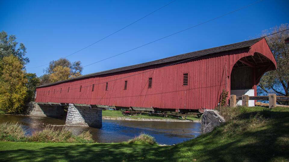A red covered bridge spanning a river.
