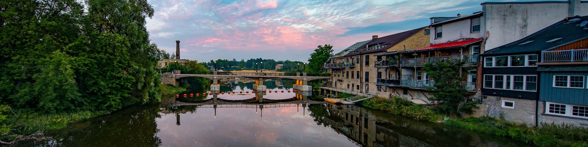 A river reflecting buildings and a bridge.