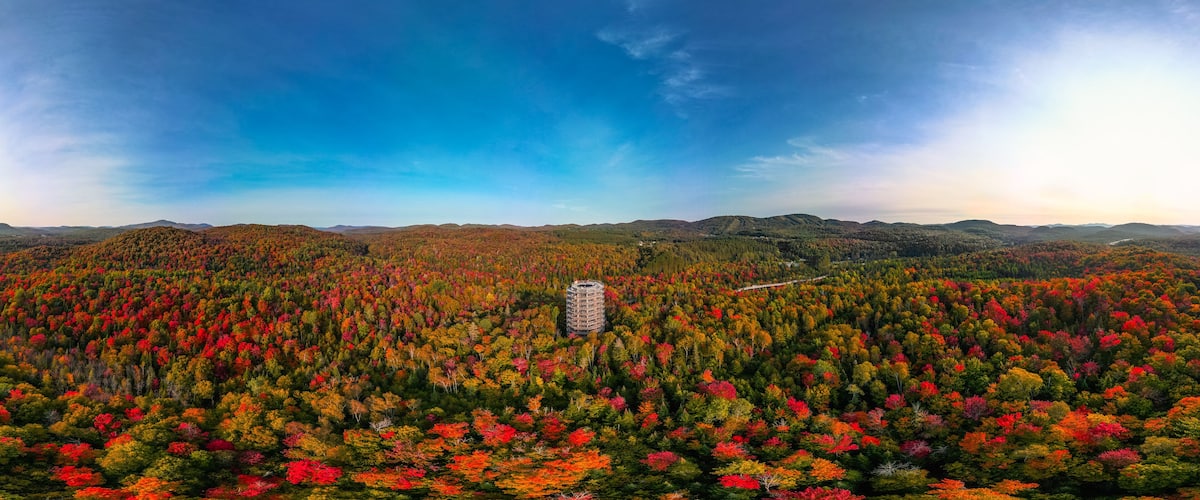 A forested mountain range with a building in the center.