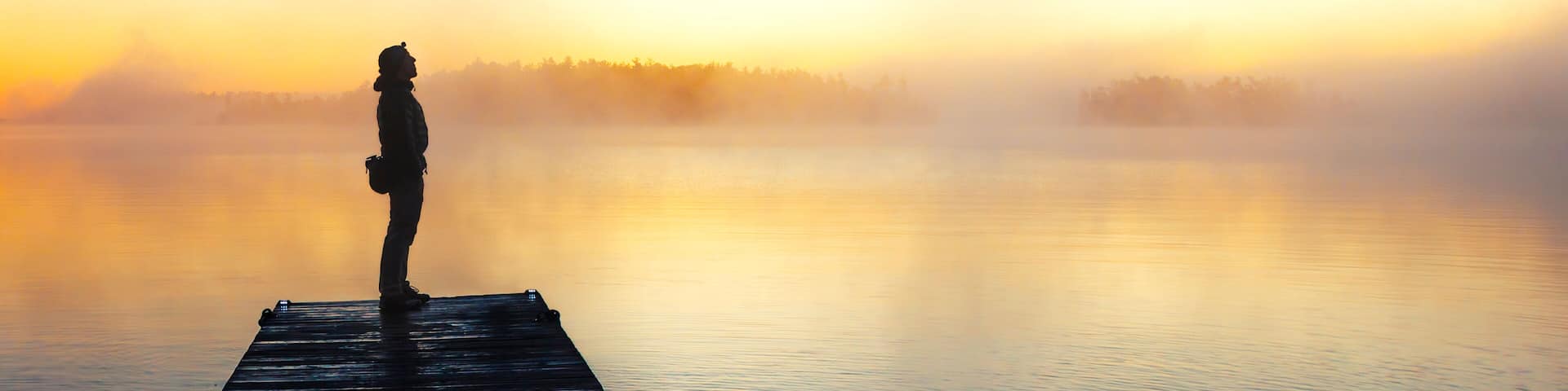 Silhouette Of A Man Standing On Dock Of The Lake Nipissing During Sunrise