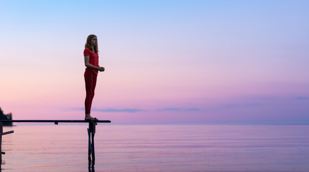 Teen Girl Looking Out at Dusk at Family Cottage on Dock at the Lake